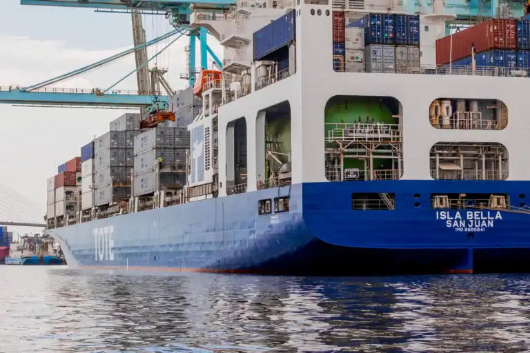 Container ship Isla Bella docked at port with stacked cargo containers.