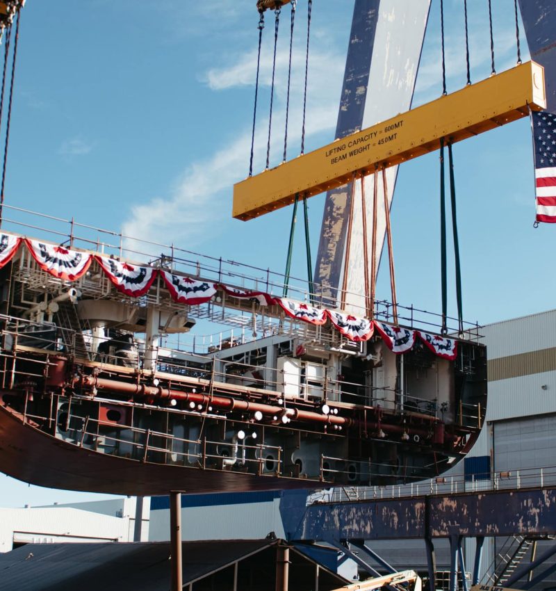 A1: Submarine being lifted by a large crane with American flag decorations.