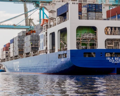 Container ship Isla Bella docked at port with stacked cargo containers.